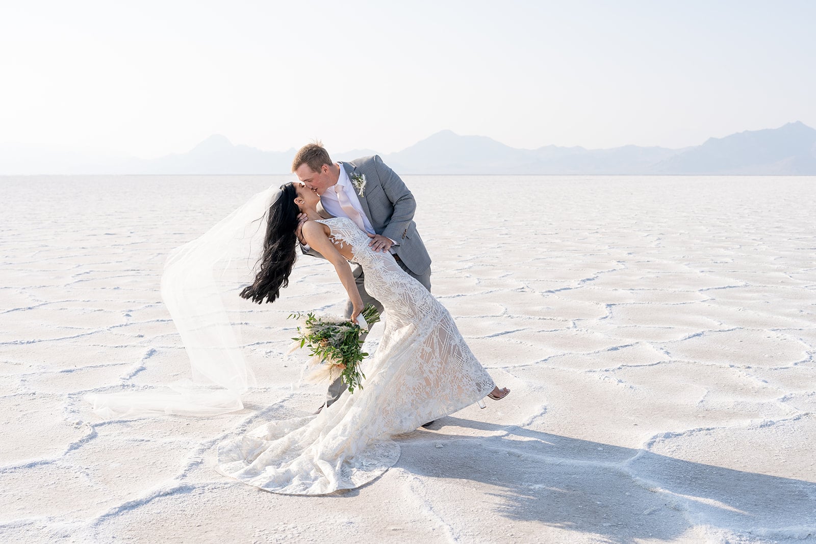 elopement at dry salt flats husband dipping wife while giving kiss