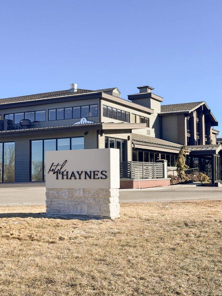 picture of hotel thaynes grass with front sign and hotel in background blue sky